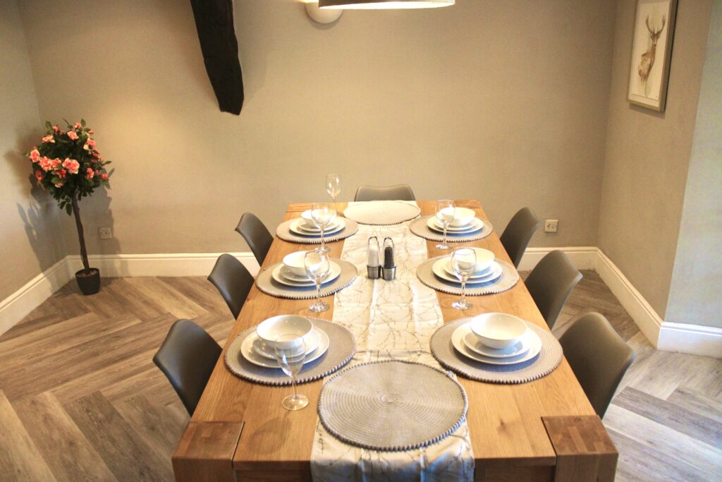 Oak dining table set for guests in the dining room at Habberjam Farm